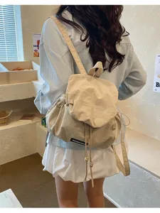 Gedetailleerd overzicht van de casual beige rugzak met trekkoord in een gezellige ruimte.
