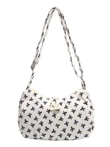 White corduroy shoulder bag with cute black bow print, adjustable strap and zipper closure.
