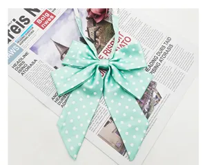 Mint green polka dot JK bow tie detail showing soft fabric texture and adjustable strap design.