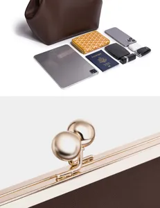 Braune Leder Kiss-Lock Handtasche mit glänzendem goldenen Kugelverschluss Detail.