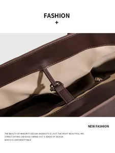 Bruine lederen tote bag interieur detail met ruim vak en elegante metalen sluiting.