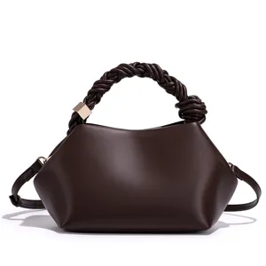 Dark brown women's crossbody bag featuring a unique braided handle and sleek shell shape design.