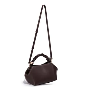 Detailed view of stylish dark brown leather shoulder bag with chic braided handle and strap.