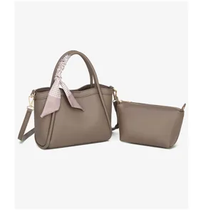 Vista detallada del elegante bolso de hombro tipo cubo gris con pañuelo elegante.