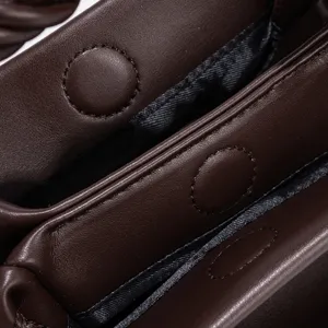 Close-up detail of dark brown leather handbag interior, multi-compartment structure, magnetic snap.