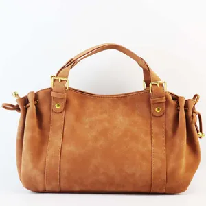 Bruine faux suède handtas detail, metalen gesp en trekkoord aan de zijkant retro stijl.