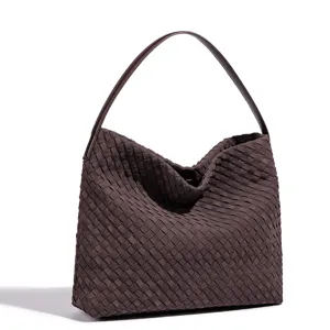 Detail view of brown woven leather shoulder bag, showcasing handmade texture and hobo style.