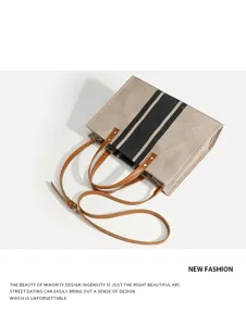 Detailansicht der kontrastfarbenen Segeltuchtasche mit braunen Ledergriffen und Schultergurt.