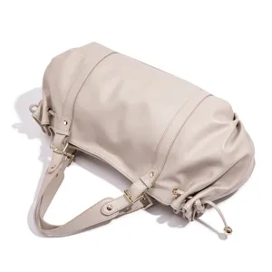 Detail view of stylish beige boston shoulder bag with metal hardware and soft leather texture.