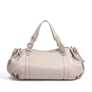 Minimalist beige leather handbag detail, featuring neat stitching and delicate metal buckles.