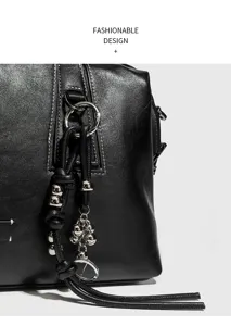 Detalle de bolso Boston de piel de vacuno vintage con dijes de cuentas metálicas finas.