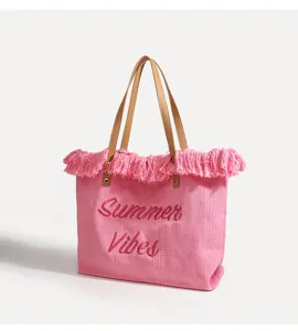 Bolso tote de lona tejida rosa vista detallada, con flecos y texto bordado de verano.