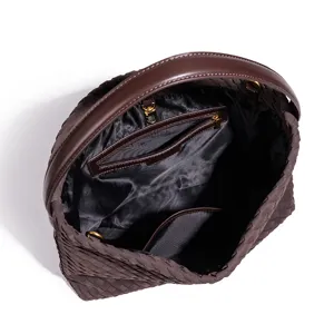 Dark brown woven leather handbag interior detail showing smooth lining and zipper pocket.