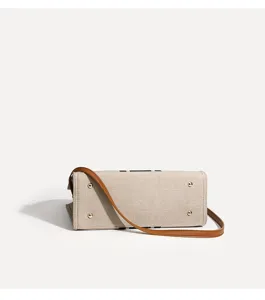 Detailansicht des Canvas-Taschenbodens mit braunem Lederriemen und Metallfüßchen.