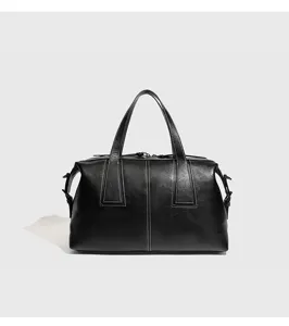 Detalle de bolso Boston de cuero negro, bolso de mano bowling vintage de gran calidad.