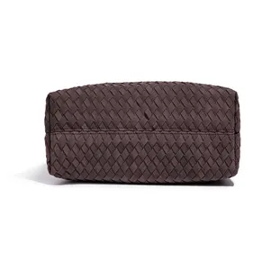 Dark brown woven leather handbag detail shot, exquisite handmade intrecciato texture.