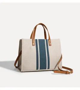 Modische Damen Canvas Tote Tasche mit Farbblock Design, braunen Griffen und Schultergurt.