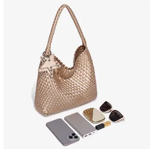 Detailed view of metallic gold woven hobo shoulder bag showcasing inner capacity and daily items.