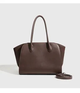 Gedetailleerd uitzicht van grote minimalistische bruine lederen tote tas met handvatten.