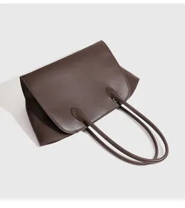 Gedetailleerd overzicht van minimalistische donkerbruine lederen shopper tas