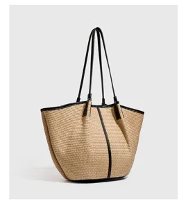 Detail van de geweven stroshopper tas, grote rieten schoudertas met stijlvol zwart leer.