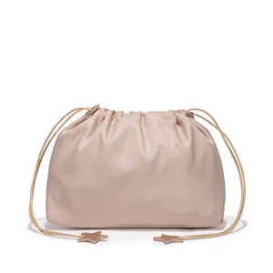 Close-up detail of the elegant beige satin drawstring pouch handbag with star charms.