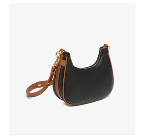 Close-up detail van de zwart-bruine halvemaan hobo tas met gouden hardware en ritssluiting.