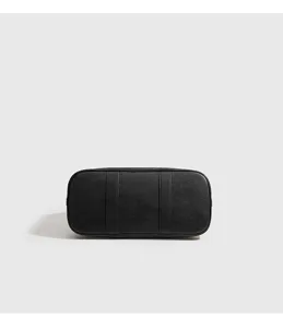 Detailansicht des Bodens der schwarzen Ledertasche, elegante und geraeumige Handtasche.