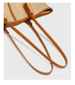Close-up detail van vrouwen raffia shopper tas met bruine lederen bandjes en nette stiksels.