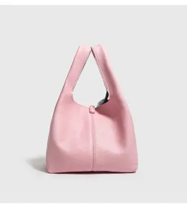 Detalle de bolso cubo de piel rosa, diseño clásico de grano, accesorio elegante diario.