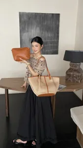 Gedetailleerd overzicht van de stijlvolle raffia geweven tote tas en bruine tas in interieur.
