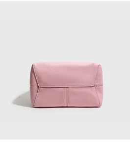 Vista detallada del bolso de cuero rosa con costuras finas y textura de calidad.