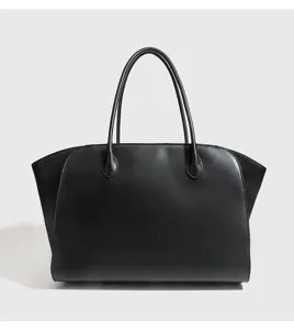 Gedetailleerd uitzicht van een minimalisten zwarte gestructureerde tote handtas met handgrepen.