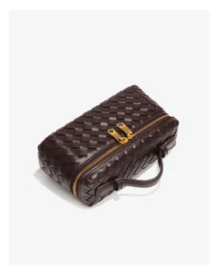 Detaillierte Ansicht der dunkelbraunen geflochtenen Leder-Boxchtasche mit goldenem Reißverschluss.