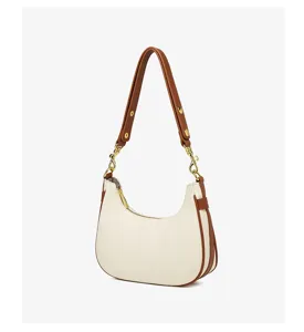 Gedetailleerde witte minimalistische schoudertas met bruine rand en gouden accenten.