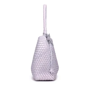 Close-up of the light purple woven handbag, highlighting the braided handle and star charm.