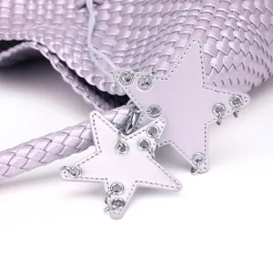 Exquisite detail view of light purple woven leather handbag featuring stylish star shaped charms.