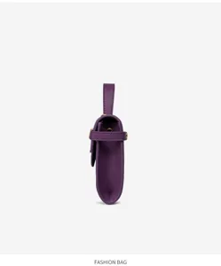 Vista lateral detallada de un mini bolso Kelly de cuero texturizado morado.
