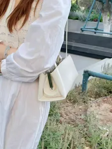 Detailansicht der eleganten weißen Retro-Bügellasche Schultertasche, stilvolles Design.