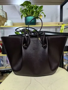 Dark brown leather tote bag with drawstring and pleated design for daily commute.