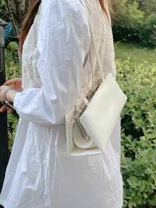 Detailansicht der eleganten weißen strukturierten Umhängetasche mit Metallrahmen und Stil.