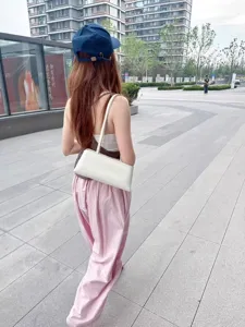 Minimalistische weiße Schultertasche als Baguette-Bag mit feinem Riemen für stilvolle Outfits.
