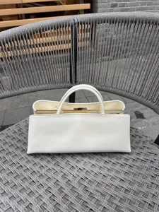 Elegante weiße strukturierte Handtasche mit Metallrahmen, schicker minimalistischer Stil.