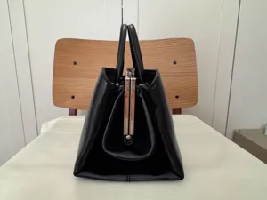 Vintage schwarze Leder Handtasche Detailansicht mit eleganter retro Schnappverschluss Mechanik.