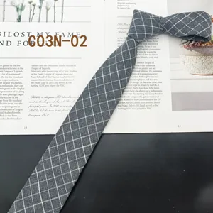 Detailed view of gray plaid narrow tie, classic retro style for business and casual wear.