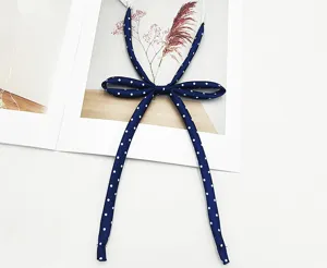 Vue détaillée d'un ruban de cravate JK bleu marine à pois, avec un design de nœud soigné.