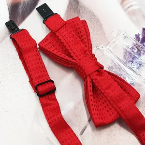 Close-up detail of a red dotted children bow tie with adjustable black strap and buckle.
