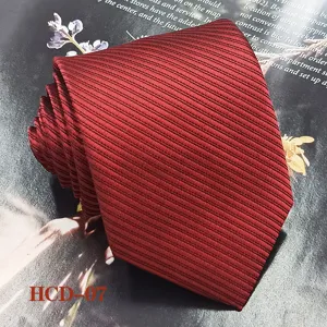 Detail view of a burgundy red jacquard woven polyester tie with fine striped texture for formal wear.