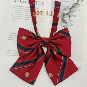 Detailed view of red and navy striped JK uniform bow tie with delicate crown embroidery.