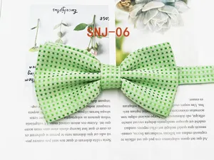 Close-up detail shot of green men's polka dot bow tie fabric texture and woven pattern.